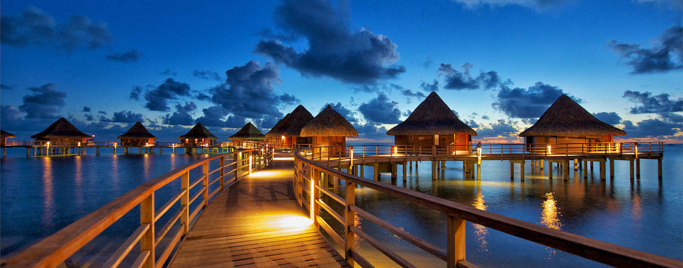 Wasserbungalows am Steg bei Nacht 