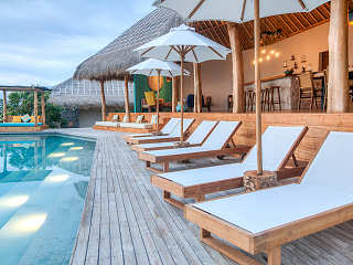 Infinity-Pool und Sonnenliegen vor dem offenen Haupthaus  © SAVU South Alor Resort