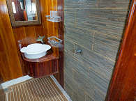 Badezimmer mit Warmwasserdusche, Waschbecken und WC 